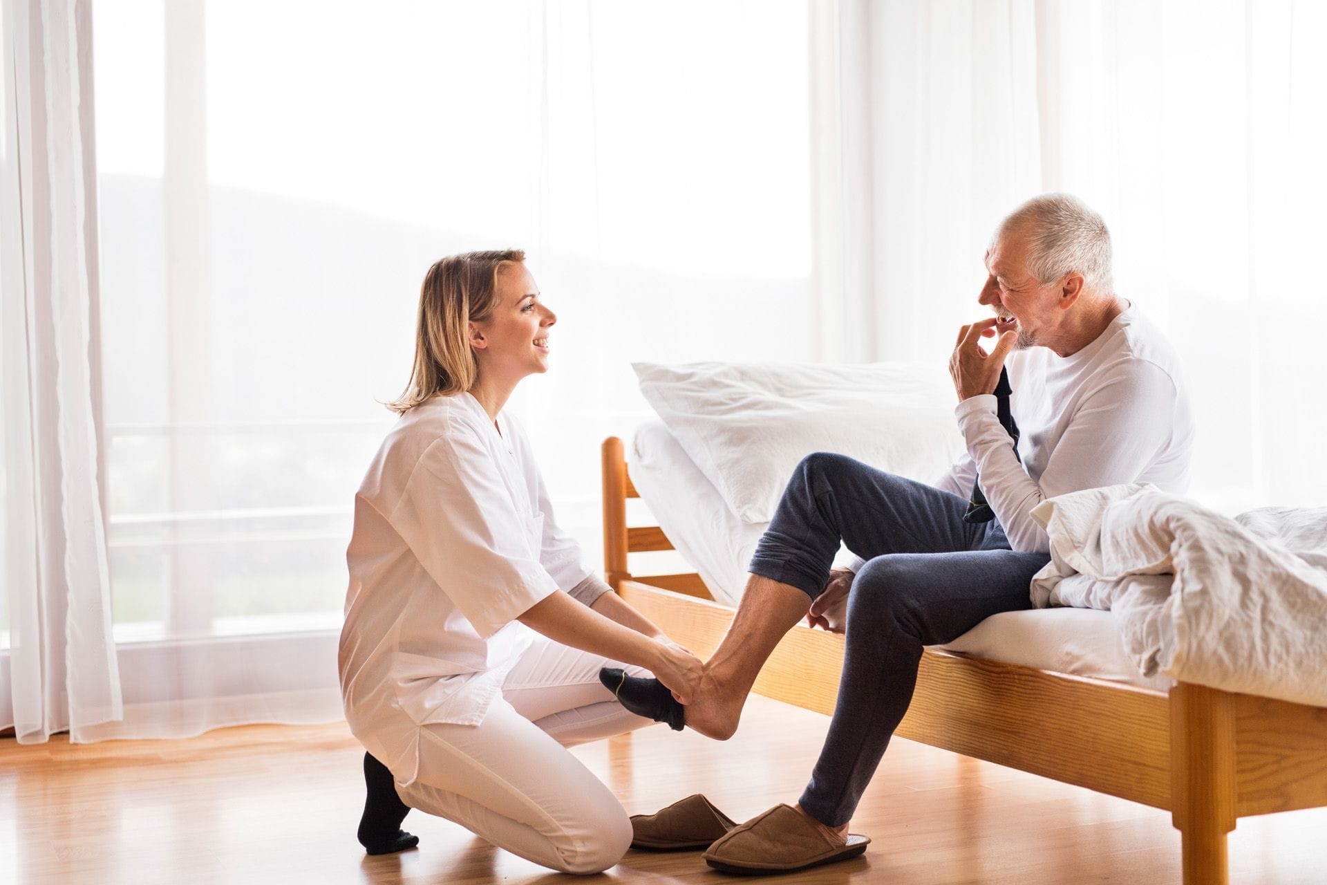 A caregiver assisting an elderly male patient