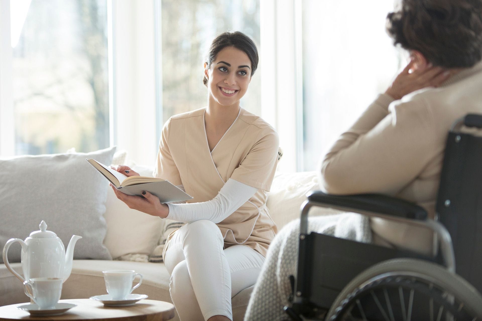 Medical social worker having a converation an elderly woman in a wheelchair