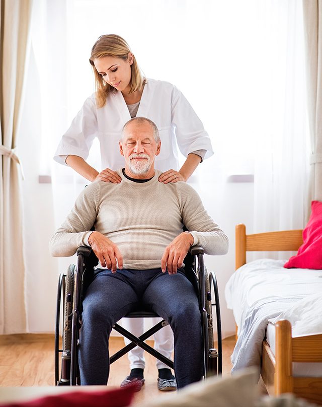 Caretaker with a male patient in a wheelchair